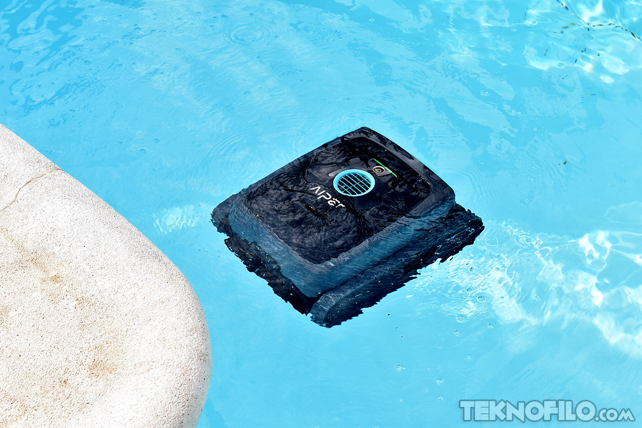 Robot limpiapiscinas AIen flotando en el agua, cerca del borde de una piscina. Tecnología de limpieza eficiente.