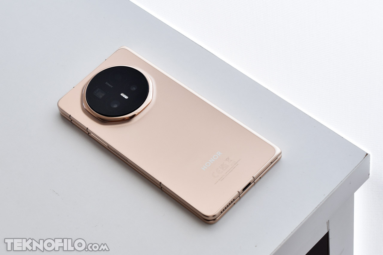 Smartphone Honor dorado con cámara circular sobre mesa blanca. Elegante diseño moderno y minimalista.