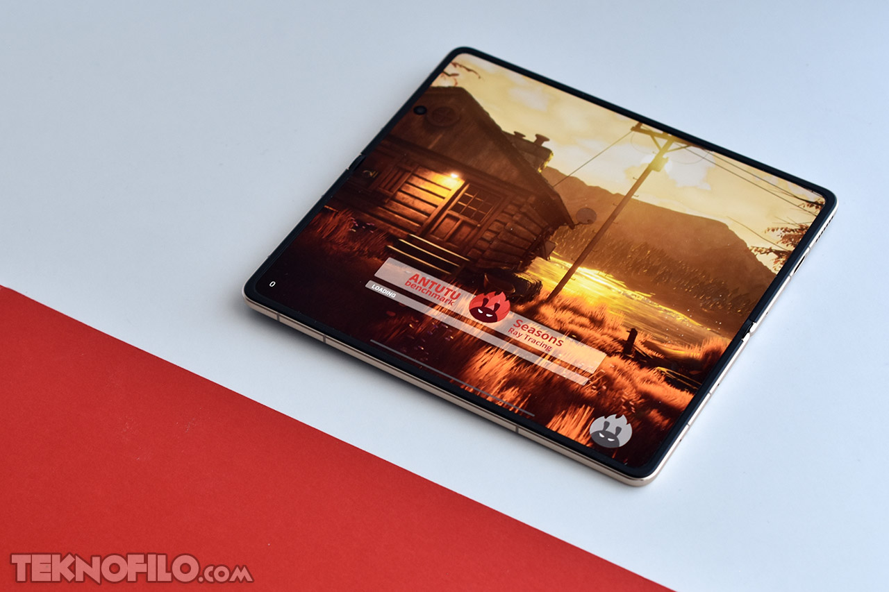 Tablet con juego de cabaña en atardecer, mostrando prueba de rendimiento AnTuTu.