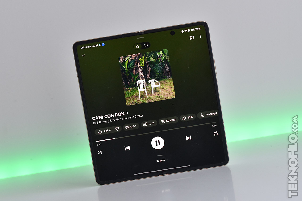 Pantalla de smartphone plegable mostrando canción Café con Ron de Bad Bunny.