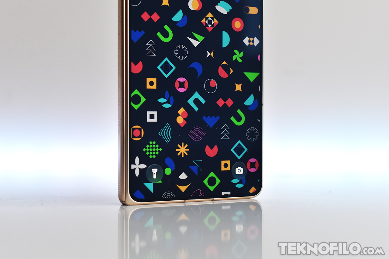 Pantalla de teléfono plegable con coloridos íconos sobre fondo oscuro, enfocada en el diseño exterior dorado.