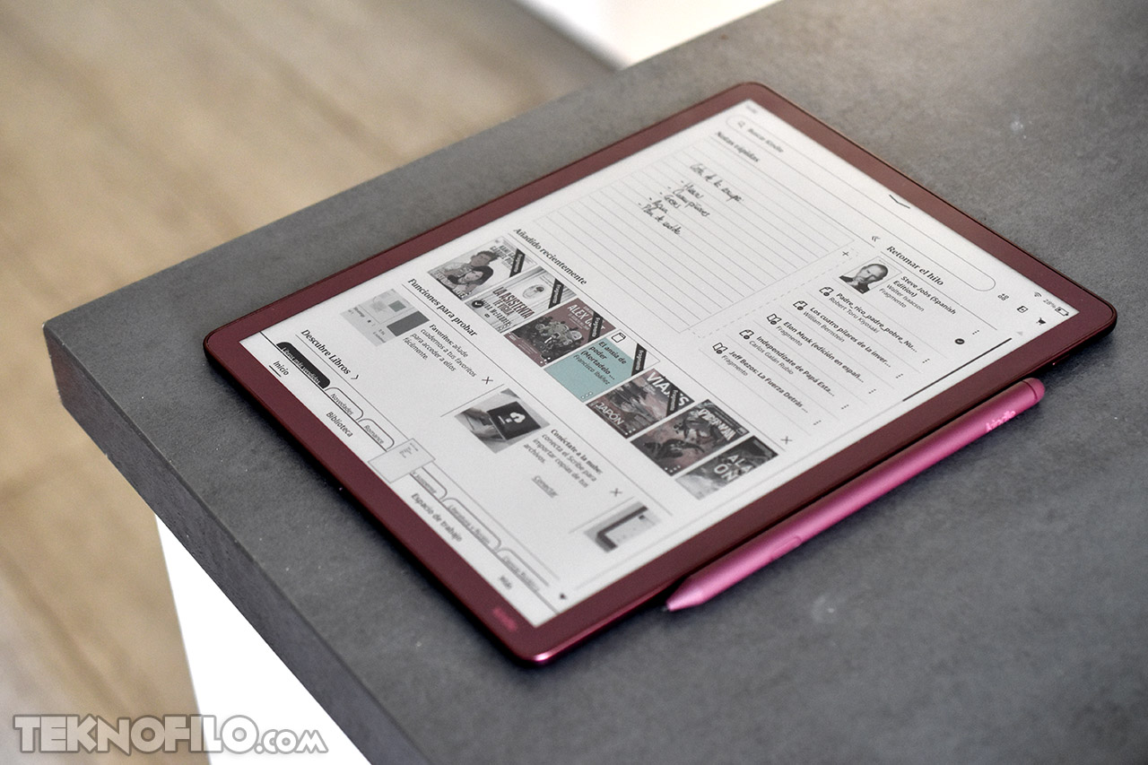 Tablet electrónica con stylus rosa, mostrando interfaz de usuario en pantalla, sobre mesa gris.