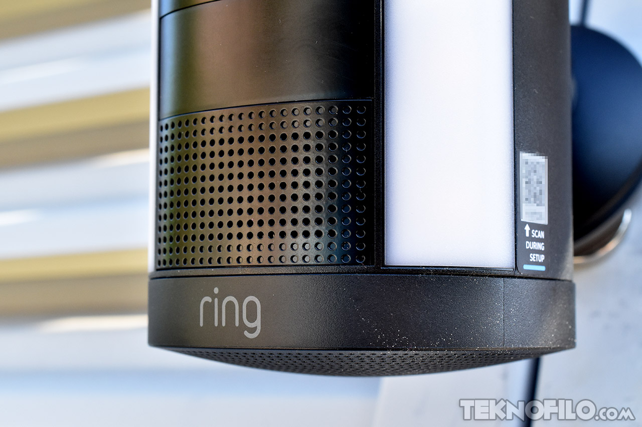 Cámara de seguridad Ring con detalle de altavoz perforado y etiqueta de configuración lateral.