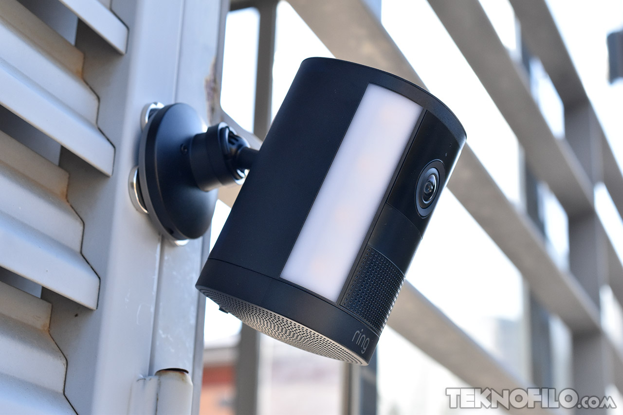 Cámara de seguridad exterior montada en pared con diseño moderno y sistema de luz.
