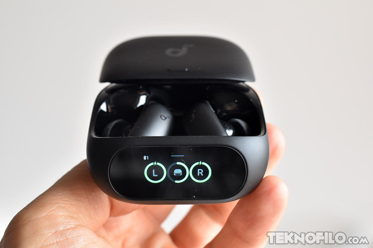 Auriculares inalámbricos negros en estuche de carga, con pantalla LED mostrando nivel de batería.