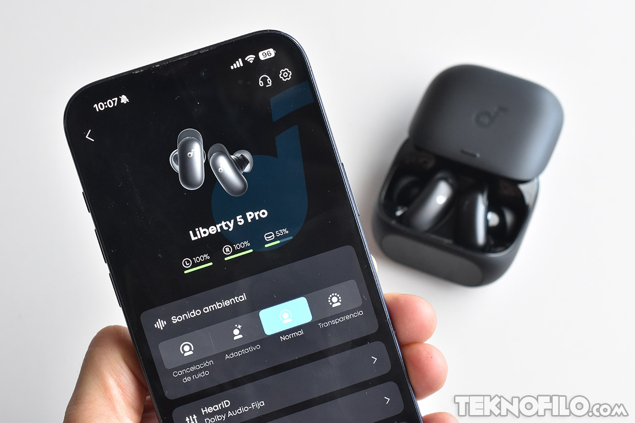 Smartphone mostrando configuración de auriculares Liberty 5 Pro con cancelación de ruido, junto al estuche de carga.