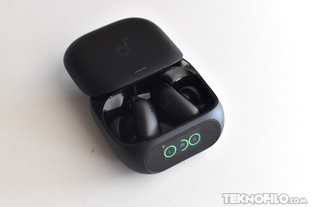 Auriculares inalámbricos en estuche negro con indicadores LED verdes, vista abierta sobre fondo blanco.