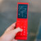 Light Flip recupera el móvil de concha para ayudarte a dejar las redes sociales Teléfono plegable rojo con pantalla GPS encendida, sostenido en una mano para navegación.