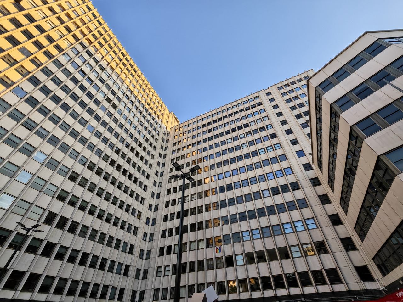 Edificios de oficinas modernos con cielo despejado al fondo, vista desde abajo.
