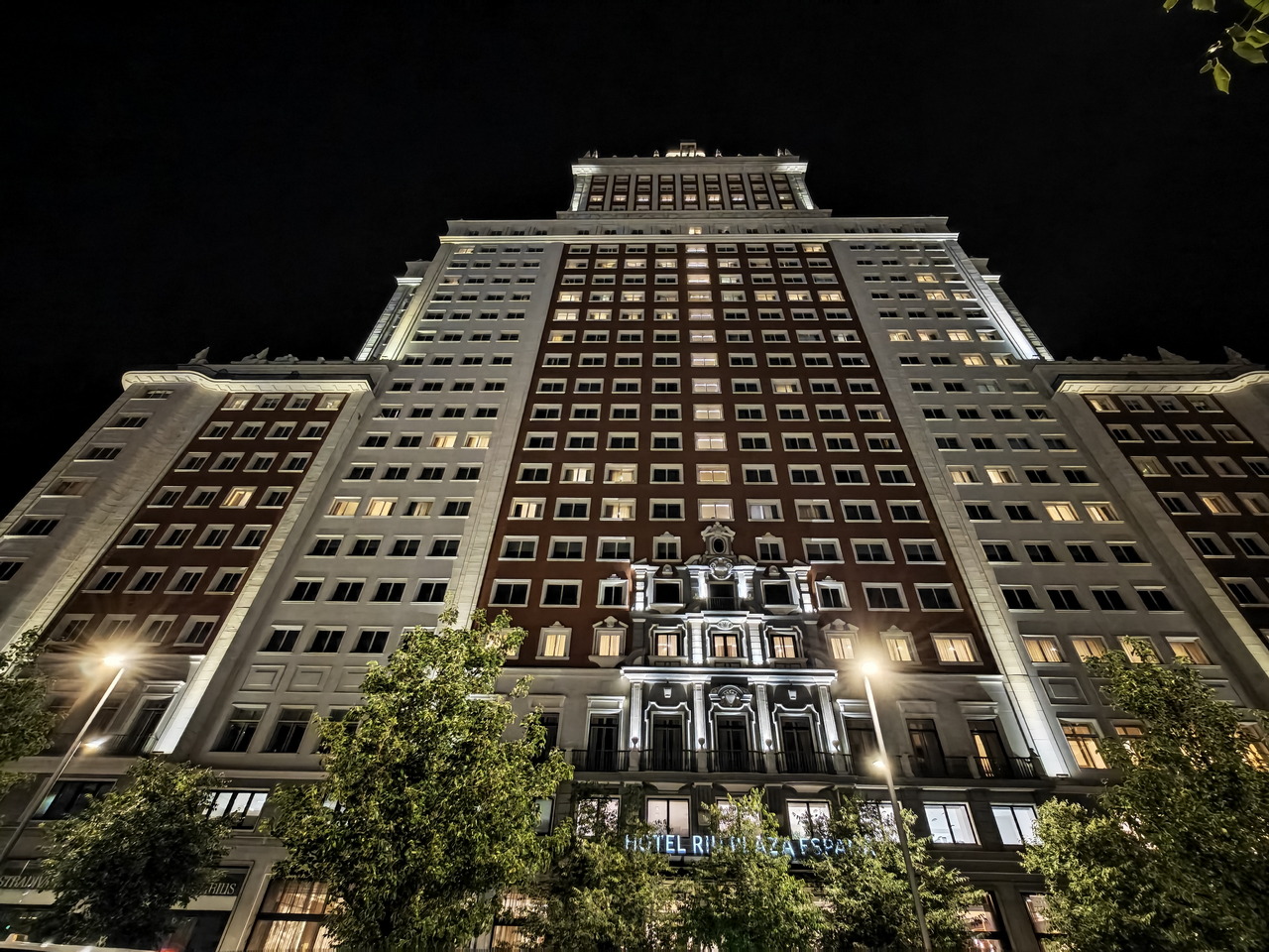 Edificio iluminado de noche en el centro urbano con detalles arquitectónicos destacados y cielo oscuro.