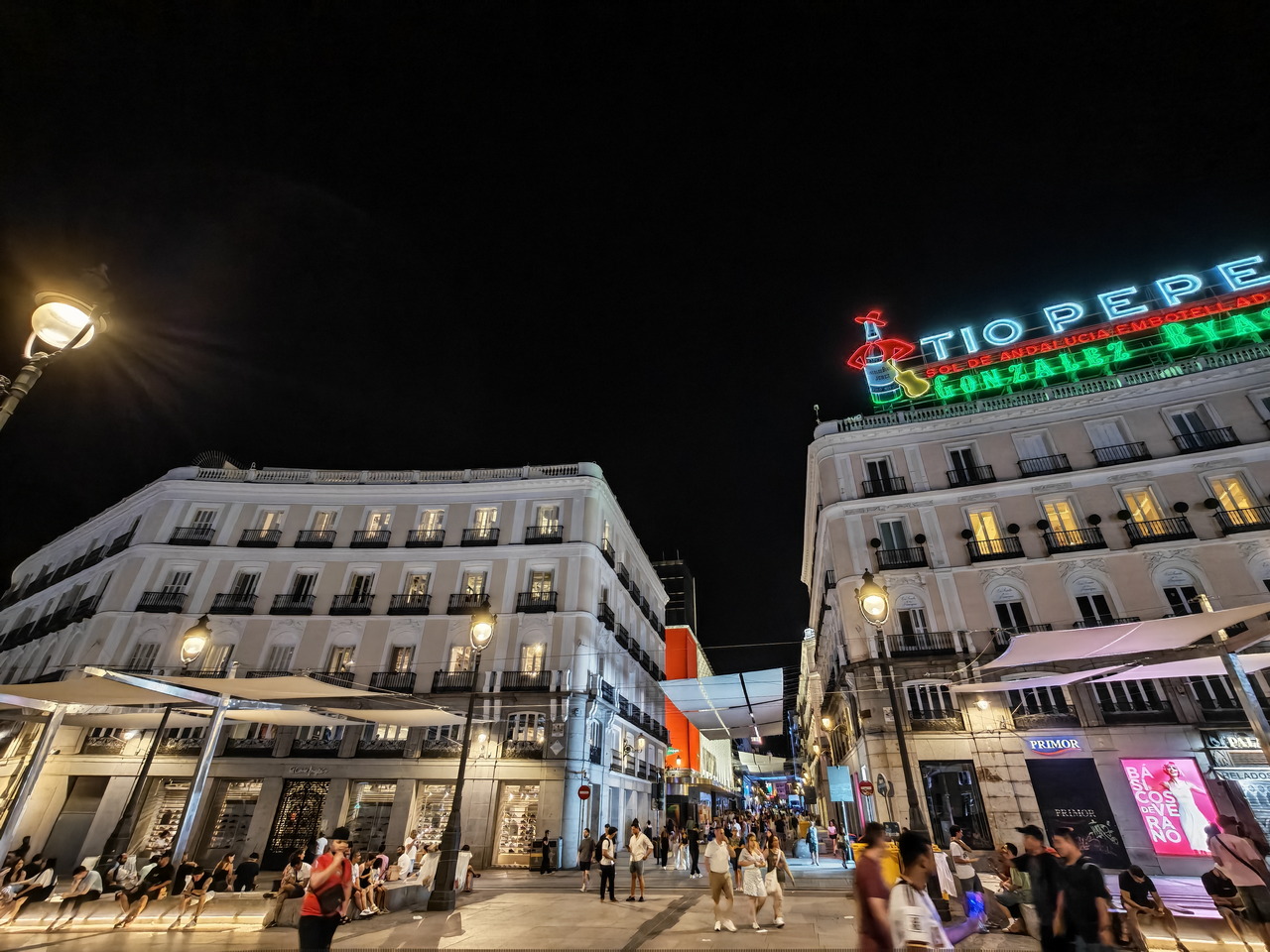 Vista nocturna de la Puerta del Sol en Madrid, con el famoso cartel de Tío Pepe iluminado.
