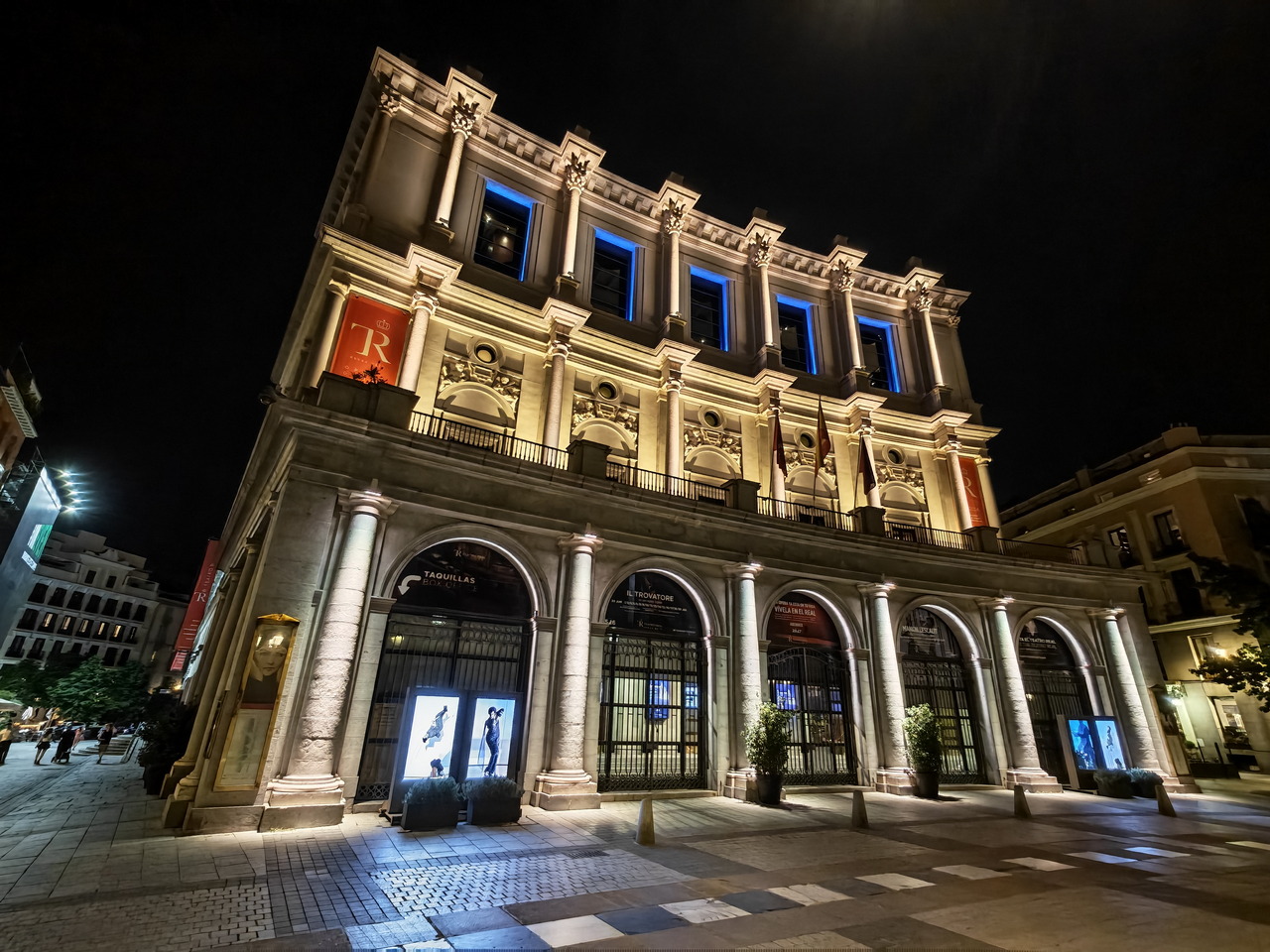Teatro Real iluminado por la noche en Madrid, España, mostrando su arquitectura histórica y elegante.