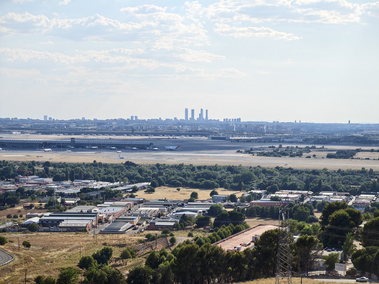 Vista panorámica del aeropuerto de Madrid con la ciudad y rascacielos al fondo, impresionantes paisajes urbanos.