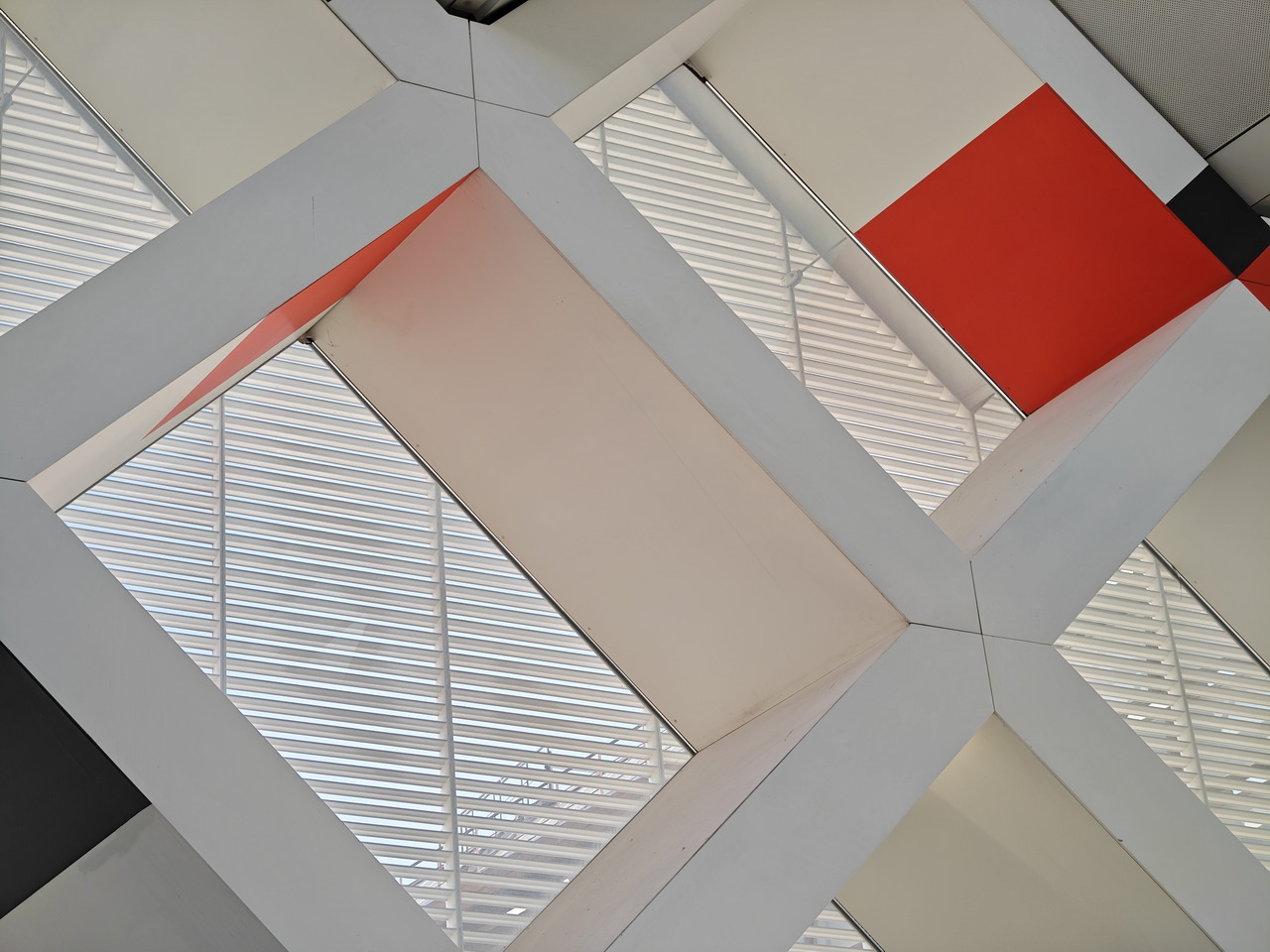 Estructura arquitectónica moderna con patrones geométricos y tonos rojos y grises.