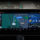 Pantalla de navegación GPS en un auto mostrando direcciones a Skyline Blvd y controles de música integrados.