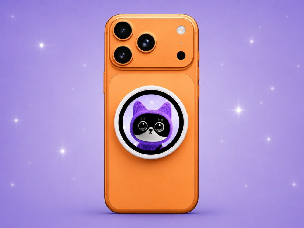 Oppo lanza una pantalla magnética para iPhone pensada para hacer mejores selfies Teléfono naranja con diseño de gato morado en soporte circular, fondo violeta estrellado.