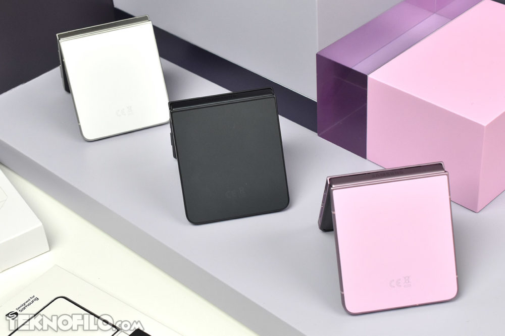 Samsung Galaxy Z Flip8: Más delgado, más ligero y más inteligente Tres smartphones plegables en colores blanco, negro y rosa sobre una mesa moderna.