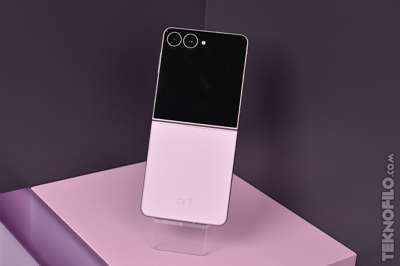 Smartphone plegable rosa con doble cámara trasera sobre fondo morado.