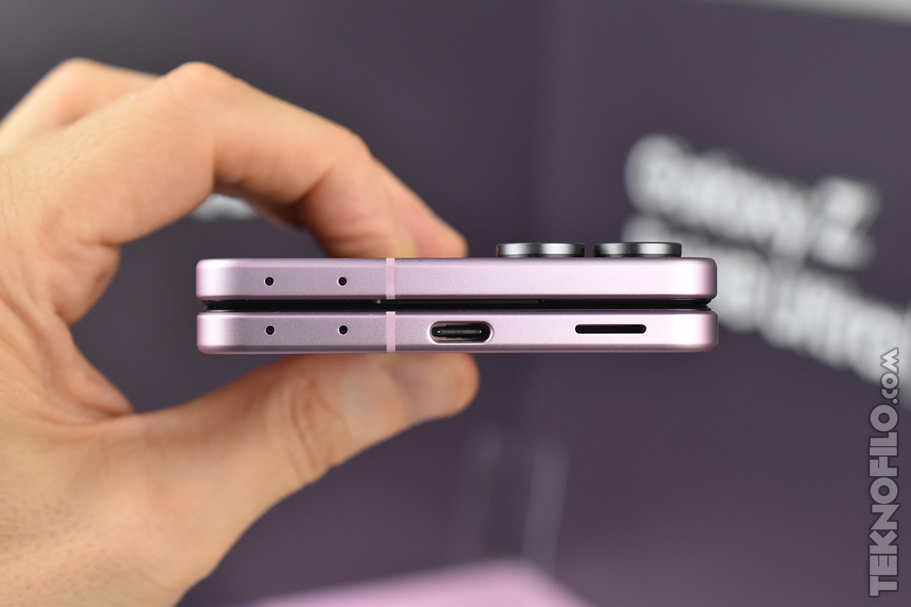 Teléfono plegable en color morado mostrando su puerto USB-C y diseño compacto.