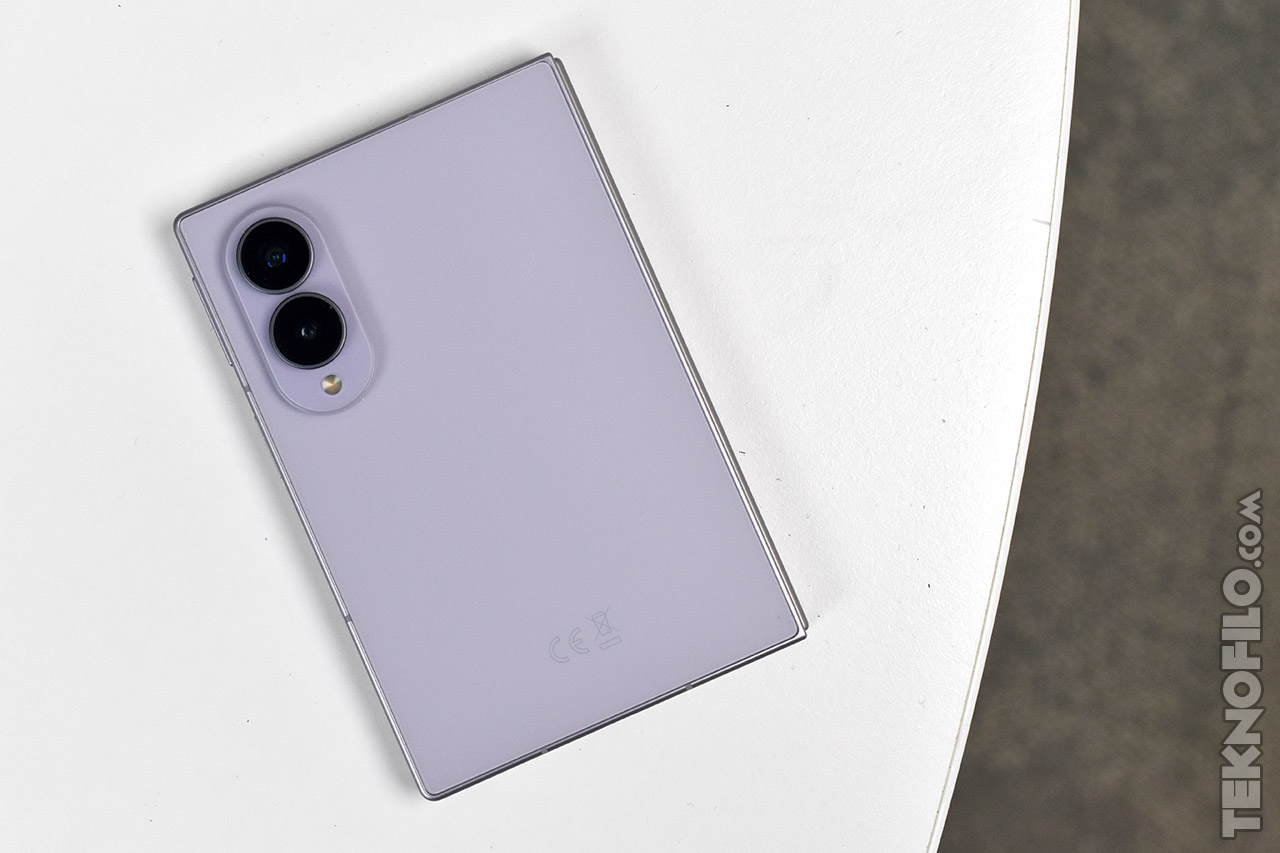Teléfono inteligente color lavanda con doble cámara sobre superficie blanca. Diseño moderno y elegante.