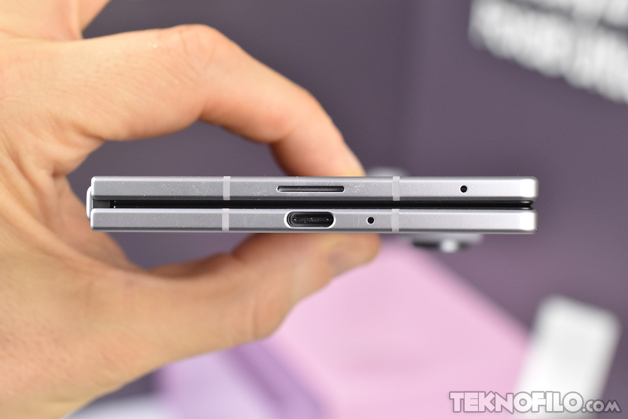 Un pliegue de smartphone con puerto USB-C, botón y micrófono, destacando su diseño compacto y elegante.