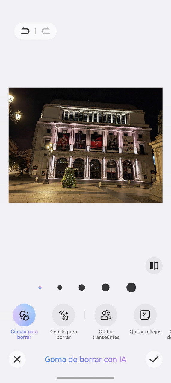 Edificio emblemático iluminado de noche con columnas y carteles, ideal para turismo cultural en la ciudad.