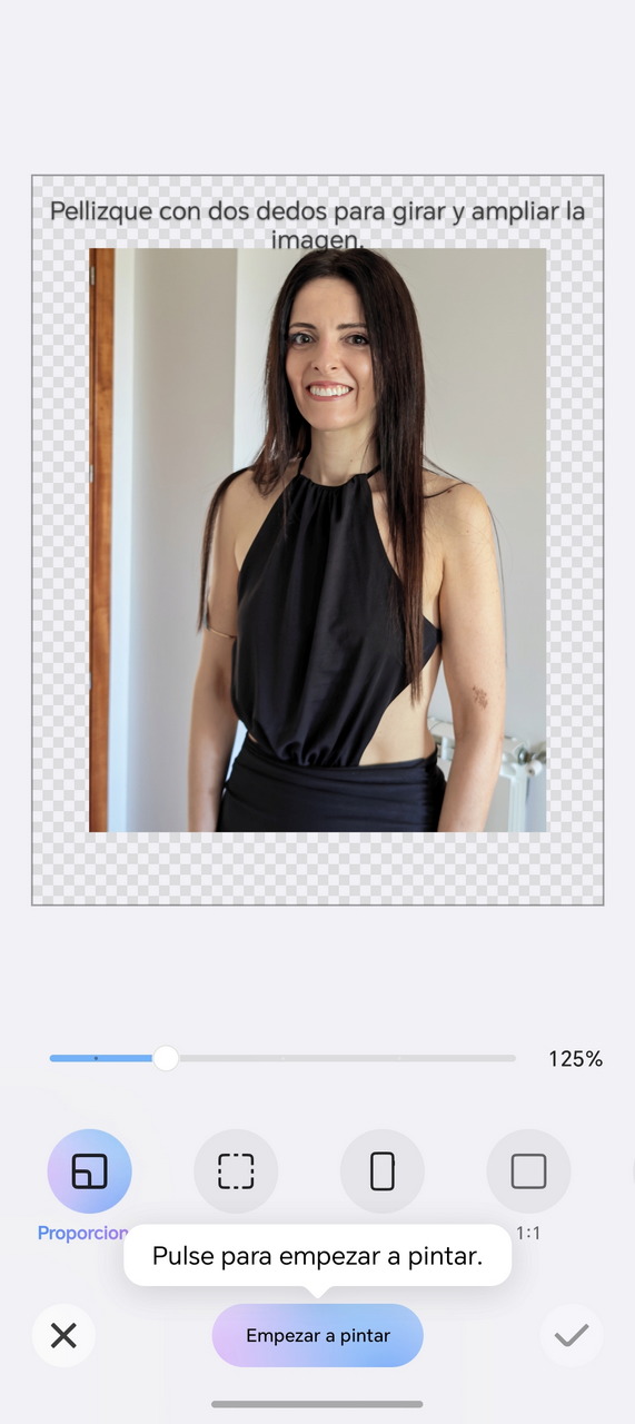 Una mujer sonriente con vestido negro sin mangas, interior de una casa.