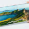 Este móvil sorprende con una pantalla que no tiene marcos Persona sosteniendo un smartphone mostrando un paisaje costero con montañas y mar, en pantalla completa.
