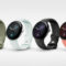 Cuatro modelos de relojes inteligentes con correas de colores: verde, blanco, negro y coral. Innovación tecnológica.