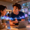 Apple prueba una IA que escucha y resume las conversaciones del Genius Bar en EE.UU. Personas conversando sobre tecnología y seguridad en una tienda de dispositivos con gráficos holográficos emergentes.