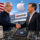 Ejecutivos estrechando manos por inversión de Apple y Broadcom en chips fabricados en EE.UU., con bandera de fondo.