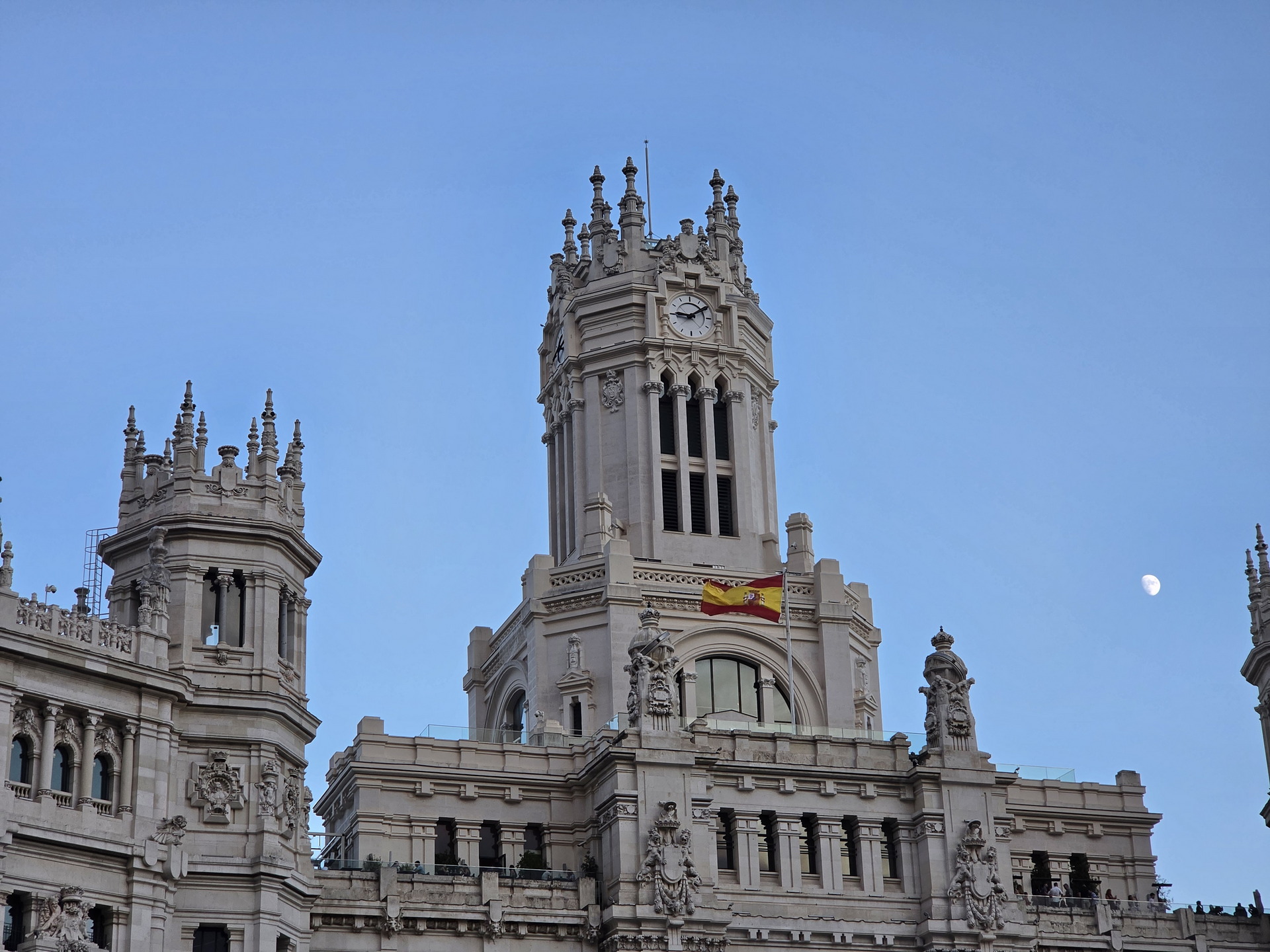 Edificio histórico con bandera de España y cielo despejado en Madrid.