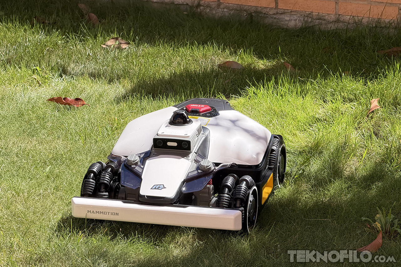 Robot cortacésped autónomo en césped verde, diseñado para cortar el césped de manera eficiente.