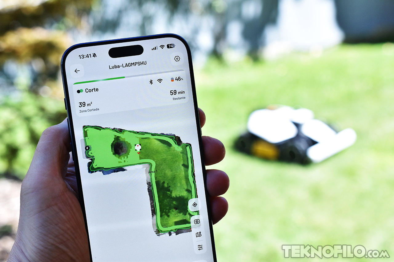 Teléfono mostrando app de control de robot cortacésped, fondo de jardín verde. Tecnología de automatización.