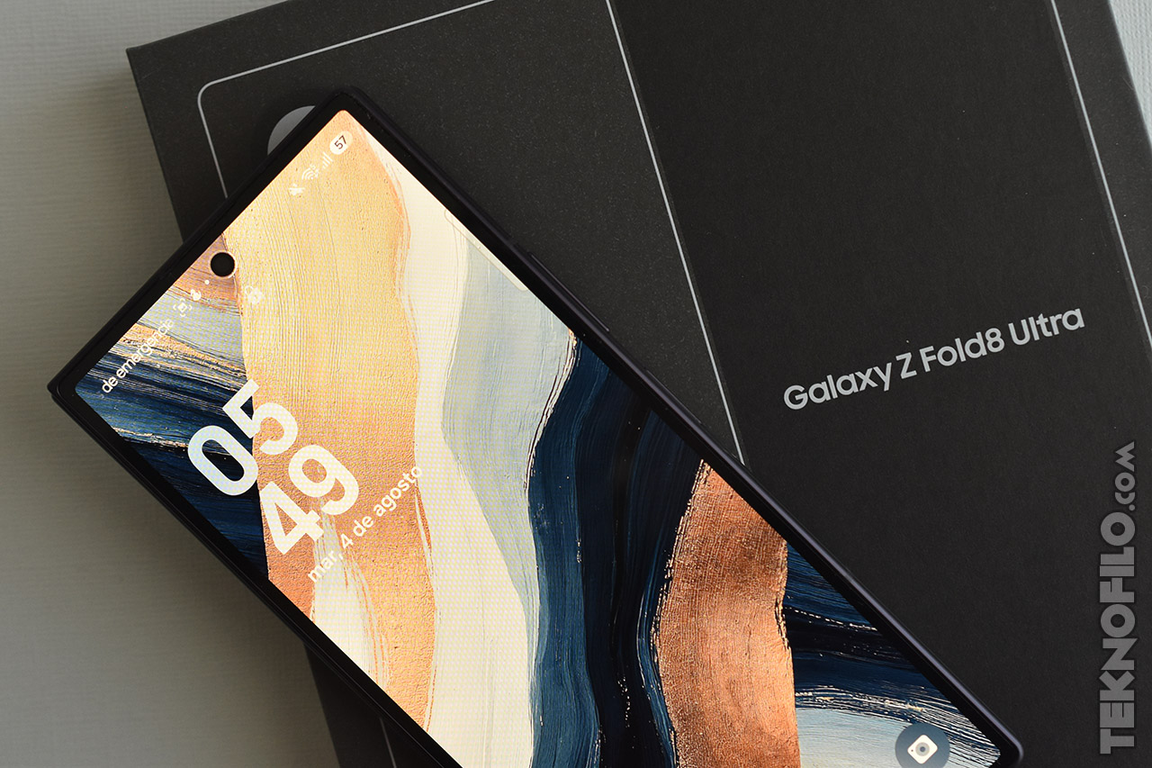 Smartphone plegable Galaxy Z Fold8 Ultra sobre caja, pantalla encendida con diseño abstracto y hora en la pantalla.