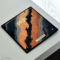 Pantalla de smartphone plegable con diseño artístico abstracto sobre una mesa blanca.