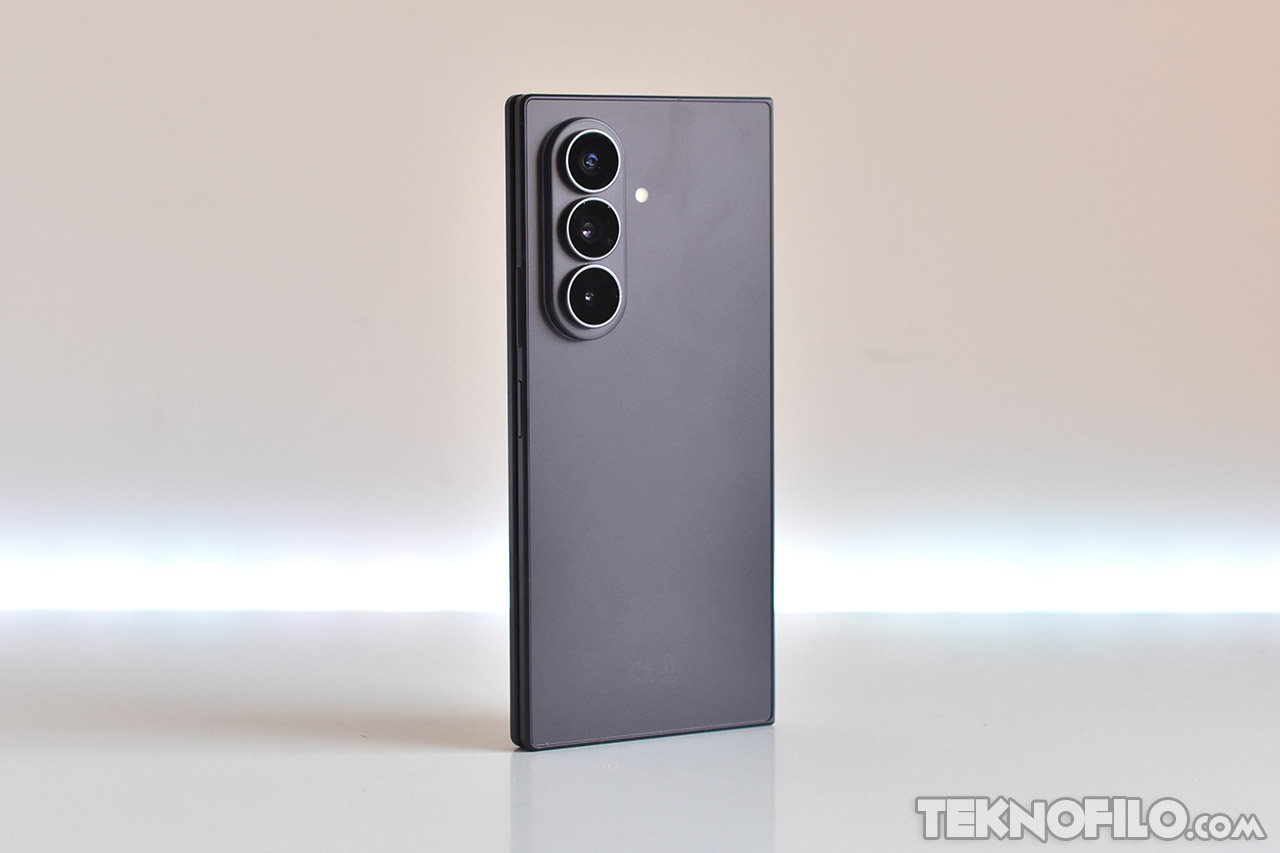 Teléfono inteligente moderno con triple cámara en diseño elegante y color negro sobre fondo blanco.