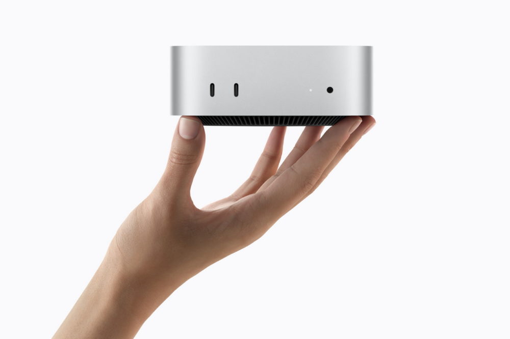 Apple presenta el nuevo Mac mini con M6 y M5 Pro: más IA, potencia y conectividad Mano sosteniendo una computadora miniatura plateada sobre fondo blanco.
