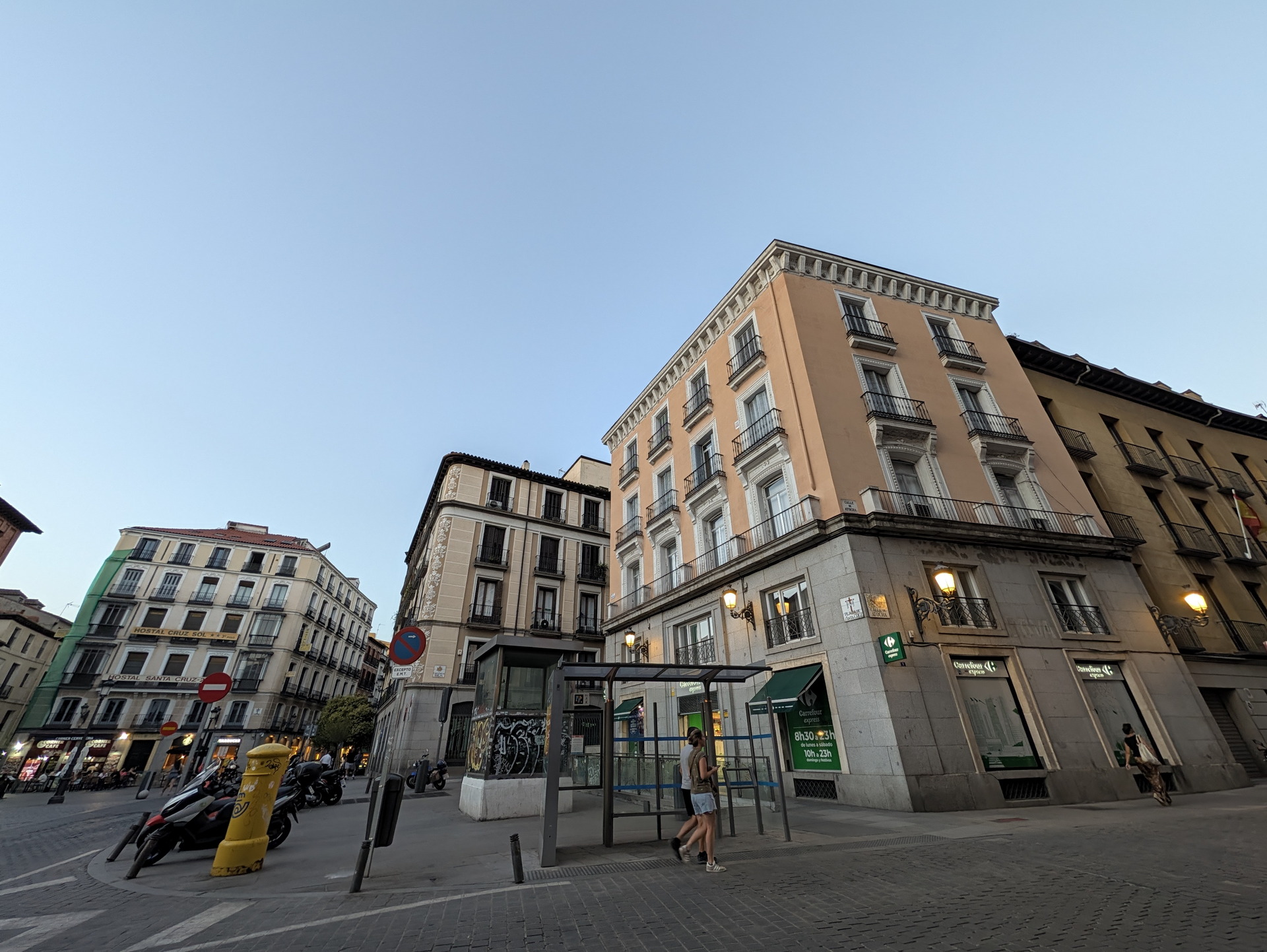 Edificio en esquina de calle urbana en Madrid al atardecer con cielo despejado.