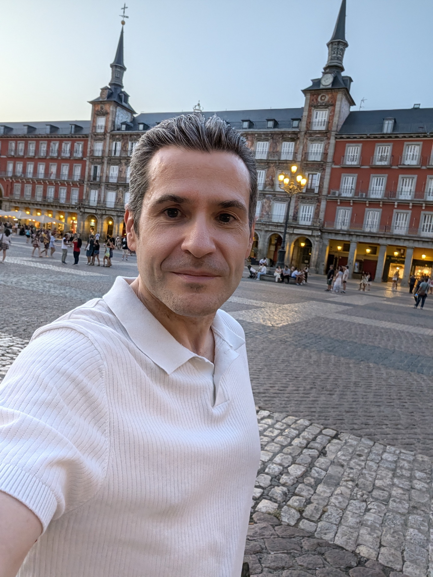 Persona tomando selfie en Plaza Mayor de Madrid al atardecer. Monumento histórico y turístico en España.