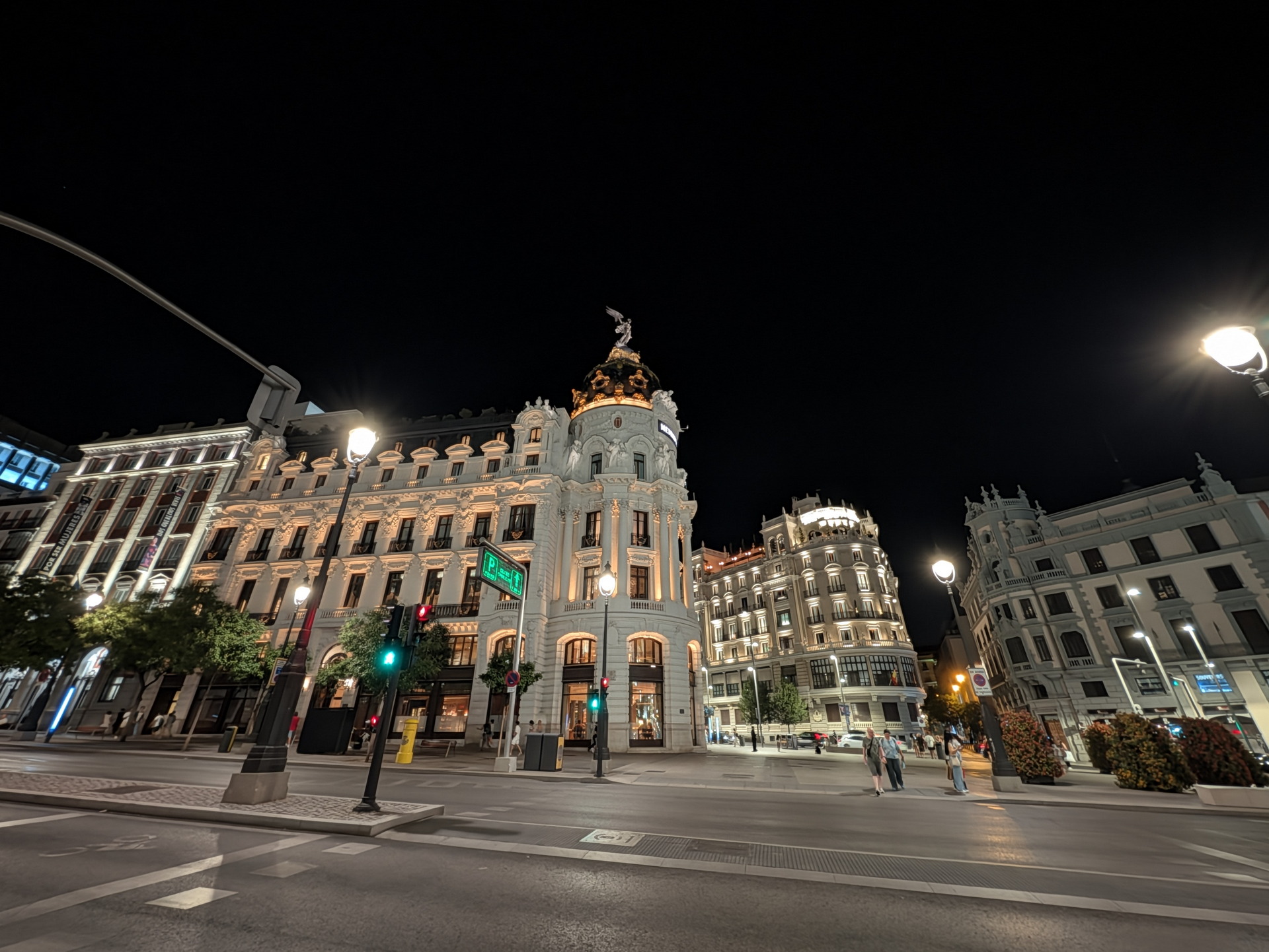 Edificio histórico iluminado por la noche en una esquina céntrica de Madrid. Arquitectura clásica y elegante.