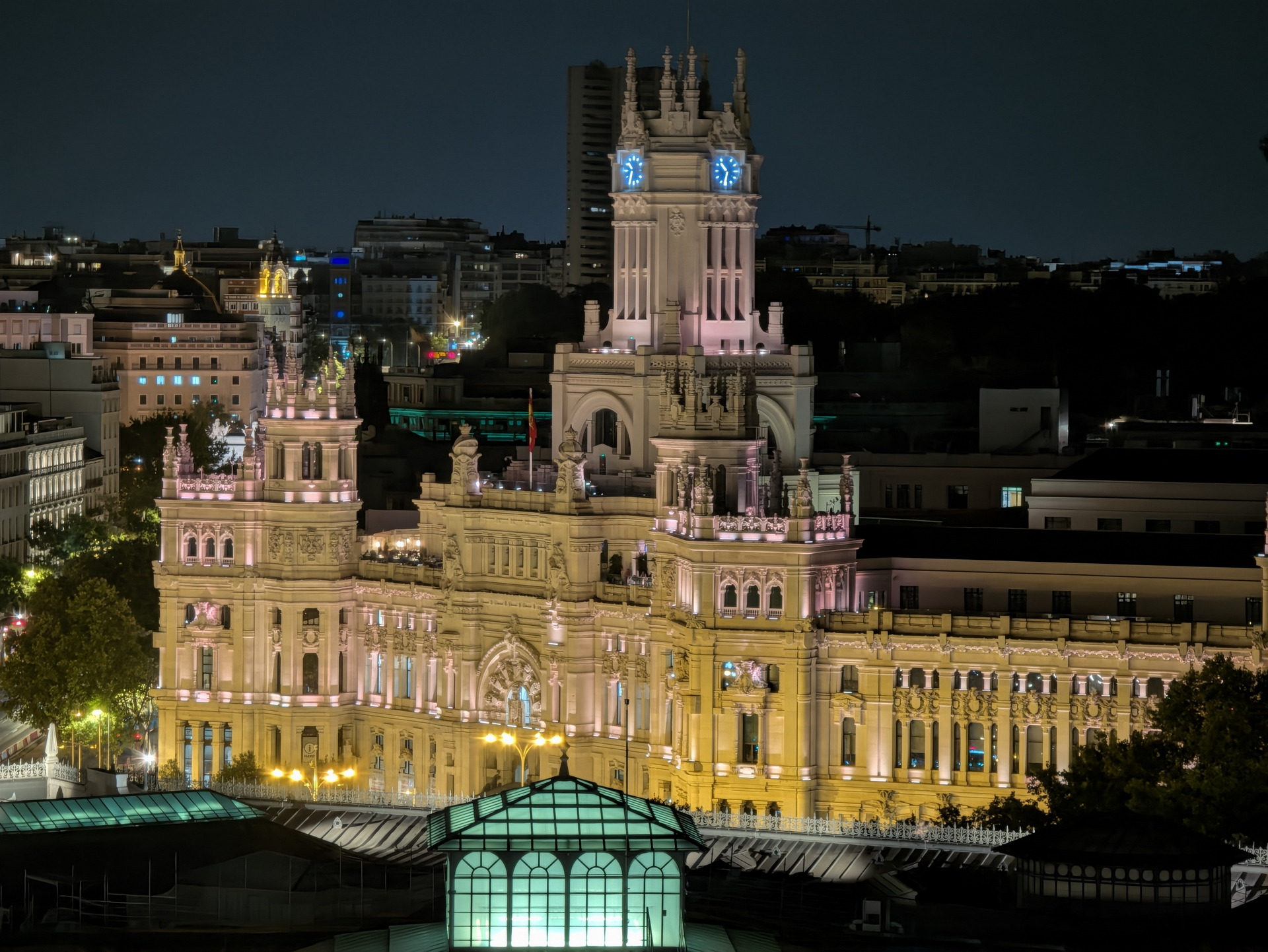 Ayuntamiento de Madrid iluminado de noche, destacando su arquitectura histórica y detalles artísticos.