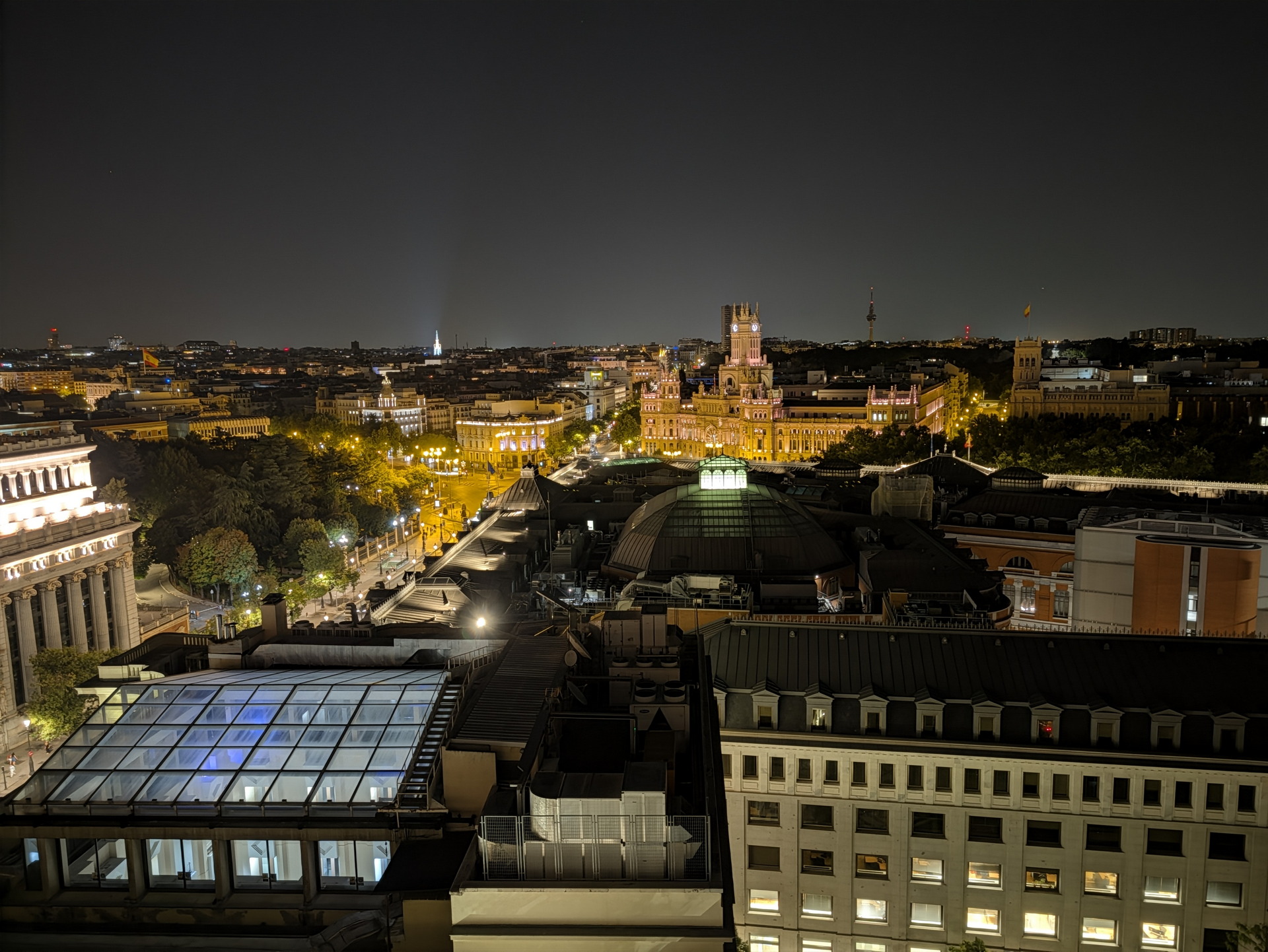 Vista nocturna de Madrid con el edificio de Correos iluminado, capturando la arquitectura y paisaje urbano.