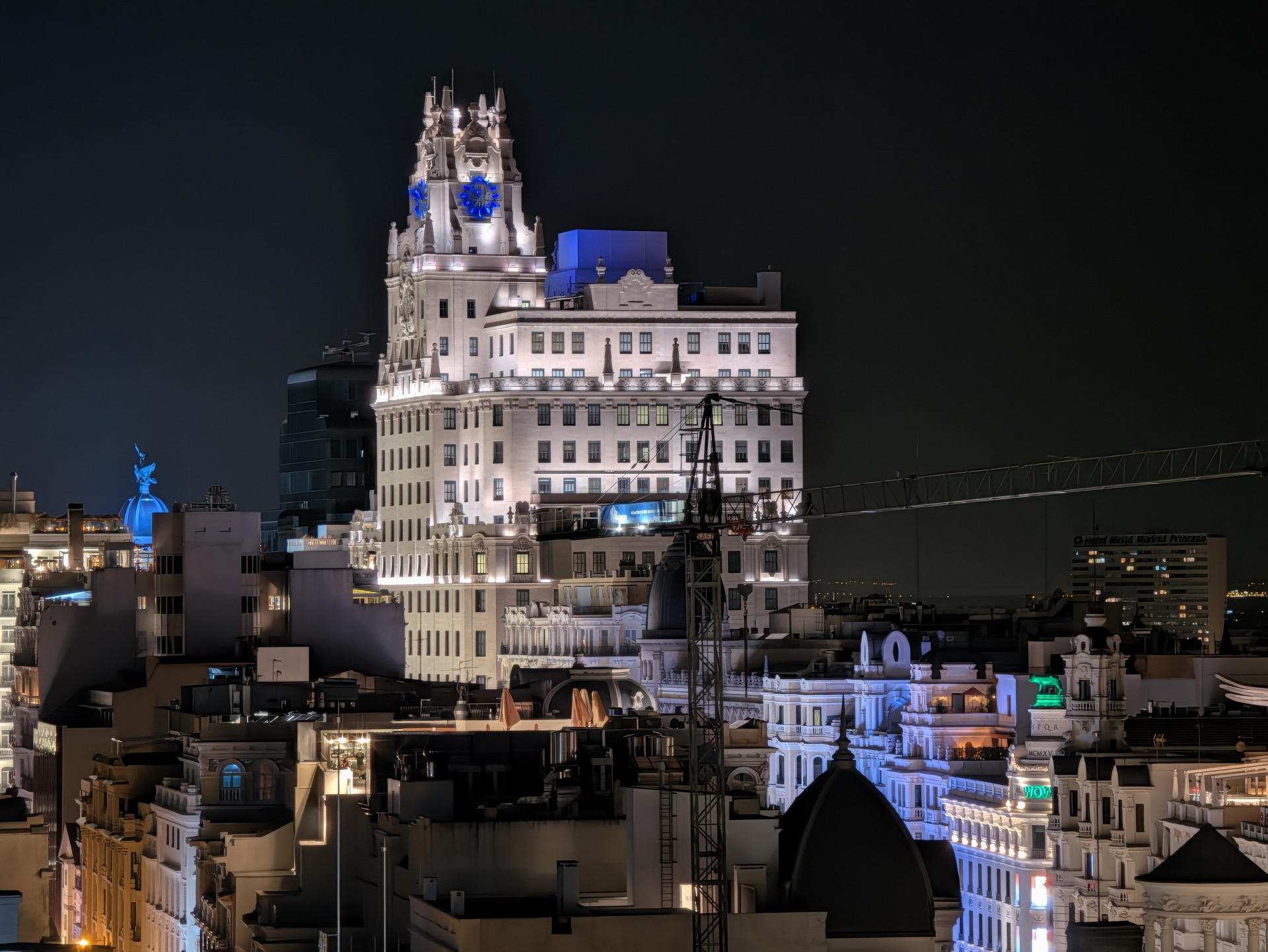 Horizonte nocturno de Madrid con edificios iluminados y cielo oscuro.
