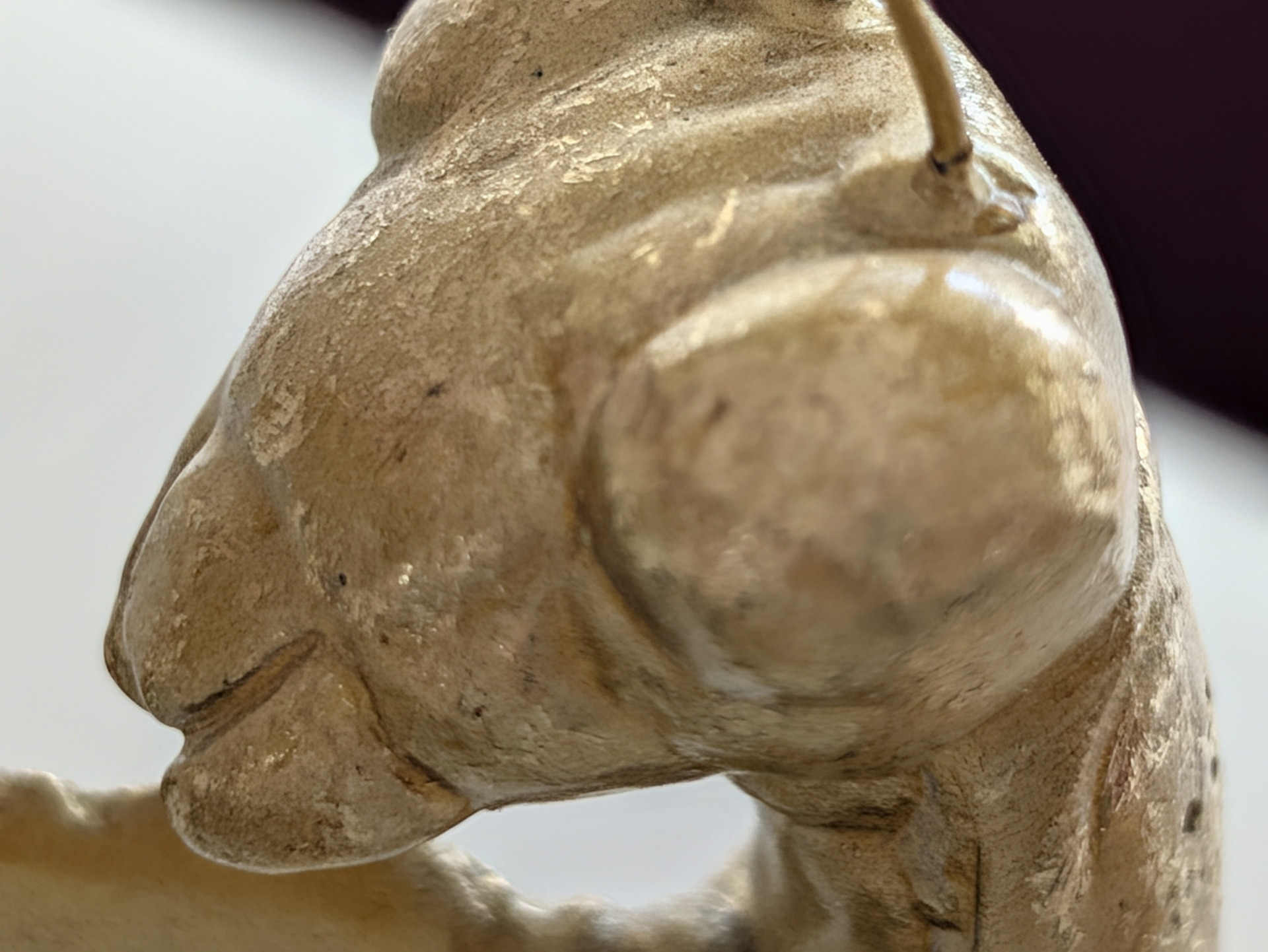 Detalle de escultura de mantis religiosa en cerámica, enfoque en la textura y detalles de la cabeza.