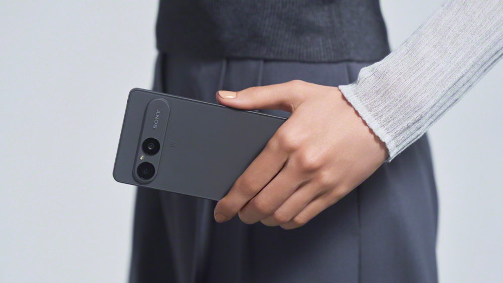 Persona sosteniendo un smartphone gris de Sony, destacando su diseño moderno y doble cámara trasera.