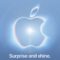 Logo luminoso de Apple sobre fondo azul claro con el texto Surprise and shine.
