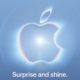 Logo luminoso de Apple sobre fondo azul claro con el texto Surprise and shine.