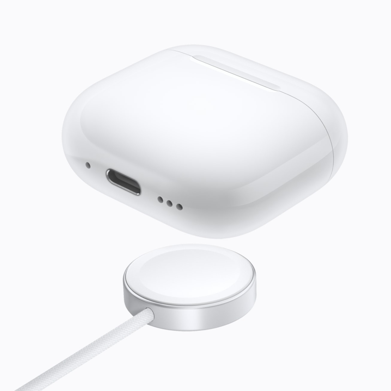 Estuche de carga inalámbrica para auriculares blancos y cargador magnético en fondo blanco.