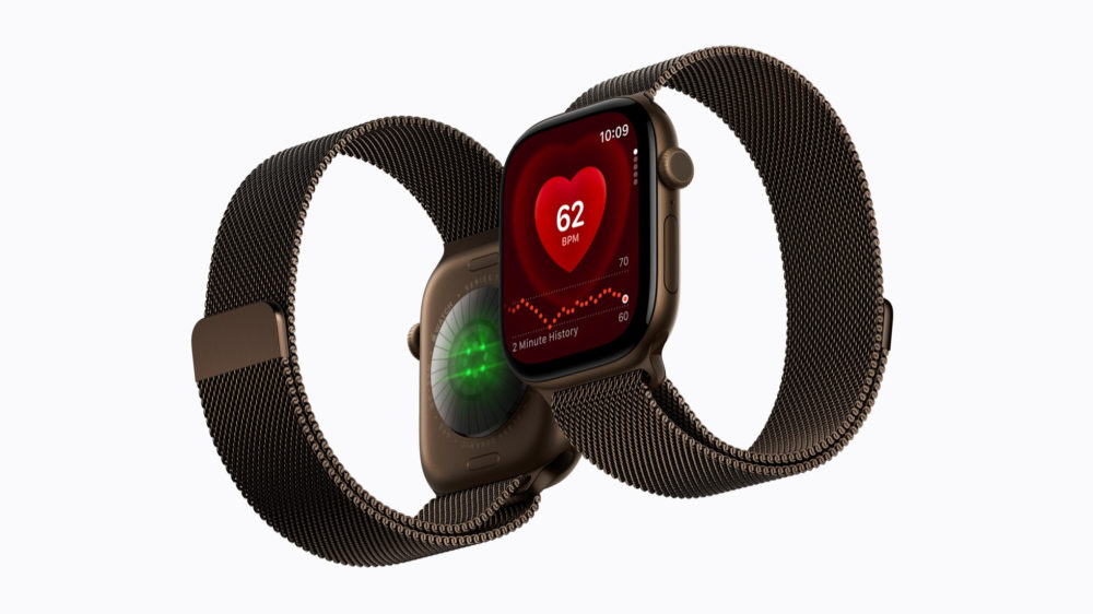 Reloj inteligente con monitor de frecuencia cardíaca, pulsera de malla metálica y pantalla con lectura de 62 BPM.
